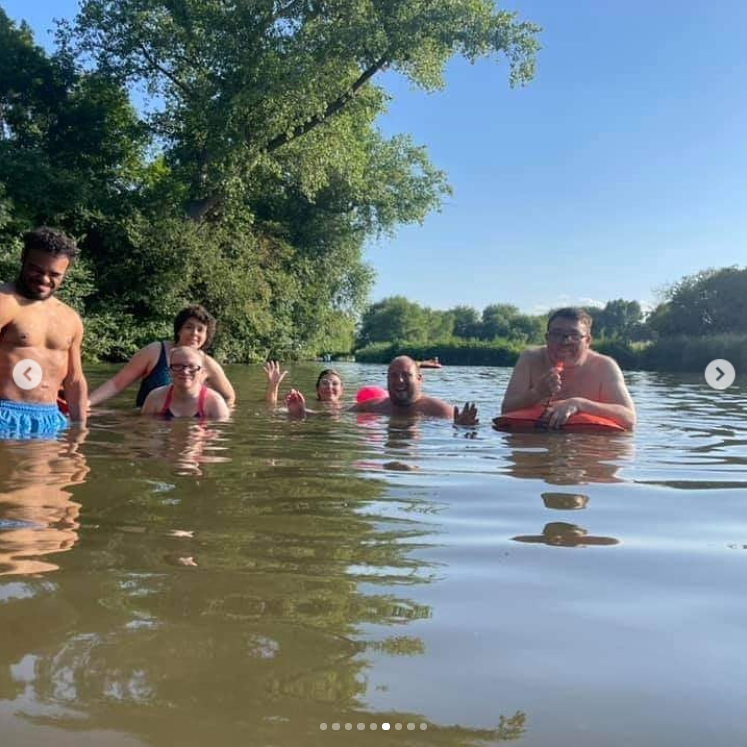 Six people stand and float in the river together on a wild swim in Warwickshire