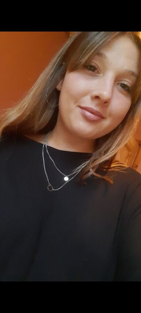 Sophie Stone, project worker at Grapevine. Sophie is a white woman with dark blonde hair, wearing a black jumper and two necklaces