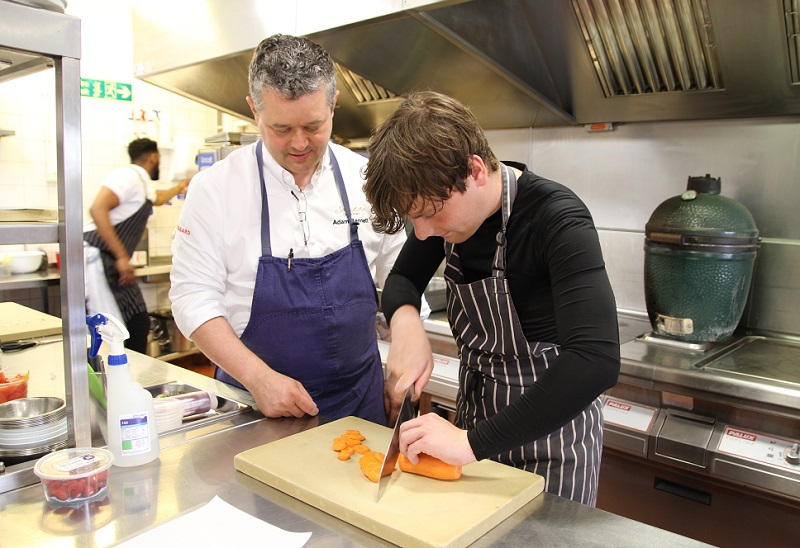 Zach learning in the kitchen with Adam