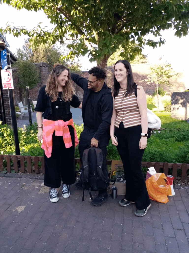 Two white women and a mixed race disabled man stand for a photo at Coventry Canal Basin looking proud they have walked 16 miles for health equity for people with learning disabilities.