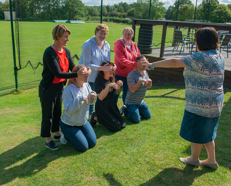 Grapevine team members act out Three Blind Mice at a team away day