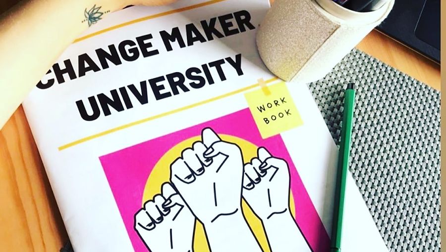 A cup rests on a Changemaker University workbook