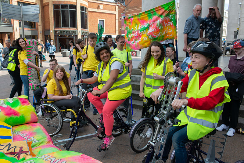 A group of young disabled people prepare to perform on their sofa on wheels in Coventry city centre. They are CYA