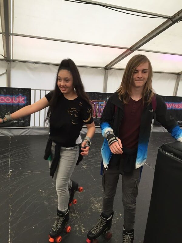 A young lady and young man go roller skating together