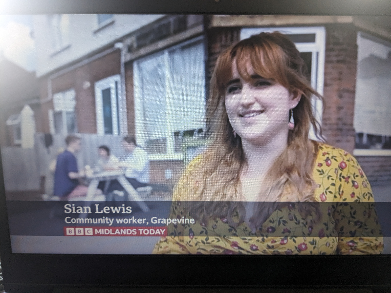 A screenshot of an interview on BBC Midlands Today with Sian from Grapevine stood outside a cafe in Coundon.