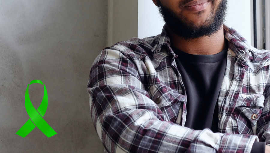 Black man in a checked shirt next to green ribbon symbolising mental health awareness